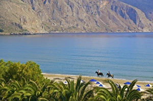 Riders Prints: Two tourists riding horses on the beach