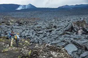 Tourists standing at a cold lava stream after an eruption of Tolbachik volcano, Kamchatka, Russia, Eurasia