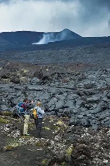 Tourists standing at a cold lava stream after an eruption of Tolbachik volcano, Kamchatka, Russia, Eurasia