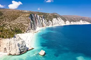 Tourists sunbathing at idyllic Fteri Beach set among cliffs and blue lagoon, overhead view, Kefalonia, Ionian Islands, Greek Islands, Greece, Europe