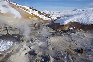 Tourists watching geothermal activity of mudpots, hot springs and fumaroles Tourists watching geothermal activity of mudpots, hot springs and fumaroles