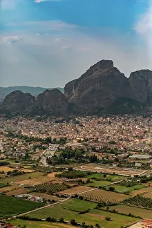 Settlement Prints: Town below rocky cliffs in Thessaly shows natural landscapes and human settlements in Meteora