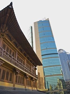 Traditional Chinese wooden architecture next to modern Chinese glass and steel buildings