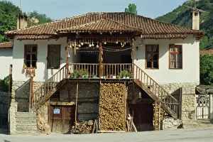 Wood Piles Prints: A traditional house with a log store, and gourds and chillies drying in the sun