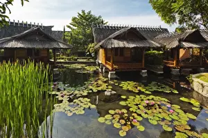 Traditional kampung style rooms over carp ponds at the Kampung Sumber Alam hot springs hotel, Garut, West Java, Java, Indonesia, Southeast Asia, Asia