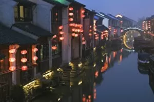 Traditional old riverside houses illuminated at night in Shantang water town