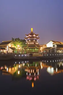 Radiant Prints: Traditional old riverside houses and pagoda illuminated at night in Shantang water town