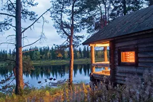 Finland Prints: Traditional sauna on the bank of the Kemijoki River during dusk in a remote Finnish landscape