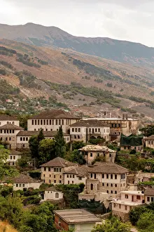 Albania Prints: Traditional stone-roofed buildings in Gjirokastr with mountainous backdrop in southern Albania