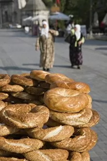 Traditional Turkish bagels with sesame seeds for sale, ladies in traditional costume in distance