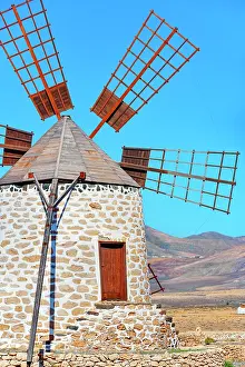 Energy Prints: Traditional windmill stands tall in Fuerteventura as the sun shines bright over Canary Islands