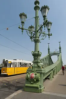 Lamps Prints: Tram and cyclist on Independence Bridge spanning Danube River, Budapest, Hungary, Europe