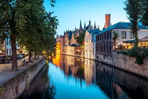 Bruges Prints: A tranquil canal scene in Bruges, with the spires of the Stadhuis (Town Hall) in