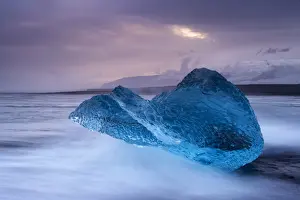 Ice Berg Prints: Translucent blue iceberg washed ashore on Breidamerkursandur black sands