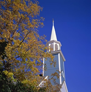 Trees in fall colours and wooden church spire at Wiscasset