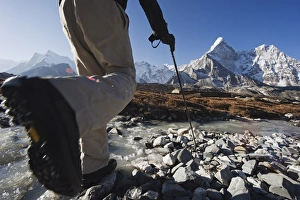 Trekker crossing a mountain stream, Ama Dablam, 6812m, Solu Khumbu Everest Region