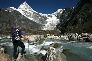 Enjoying Prints: A trekker pauses for a break on the edge of a glacial stream on the way to Mera Peak
