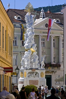 The Trinity Column dating from 1714 and people walking around Hauptplatz surrounded by 18th century buildings, Baden The Trinity Column dating from 1714 and people walking around Hauptplatz surrounded by 18th century buildings, Baden