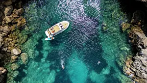 Swimming Prints: Turquoise waters and boat activity seen from above at Alcudia peninsula in Mallorca, Spain