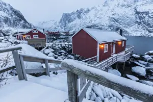 Typical fishermen houses called rorbu in the snowy landscape at dusk, Nusfjord, Nordland County