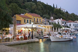 Taverna Prints: Typical waterfront taverna illuminated at dusk