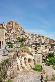 Cappadocia Prints: Uchisar town features traditional houses and a rocky landscape under a clear sky in Cappadocia