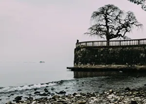 Contemplation Gallery: Unidentified woman looking at Lake Maggiore on a cold winters day, Piedmont, Italian Lakes
