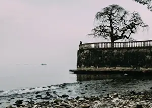 Balustrade Prints: Unidentified woman looking at Lake Maggiore on a cold winters day, Piedmont, Italian Lakes