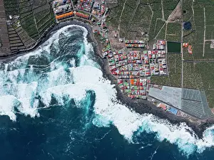 Ocean Waves Prints: Vertical aerial view from the drone of a little coastal village with colorful roofs