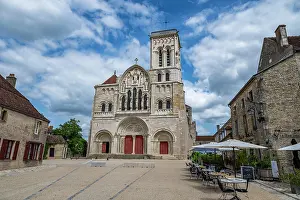 Cafes Prints: Vezelay Abbey stands with its detailed facade in a hill town of France under a partly cloudy sky