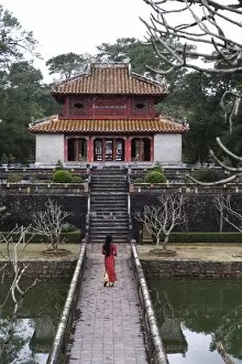 Vietnamese schoolgirl walking over bridge to Minh Lau Pavilion (Bright Pavilion)
