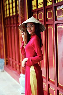 Eye Contact Gallery: Vietnamese woman in traditional Ao dai dress and Non la conical hat, Hanoi, Vietnam