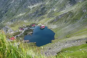 Relax Prints: View of Balea Lake in Fagaras Mountains during a sunny day with green hills surrounding the blue water in Romania