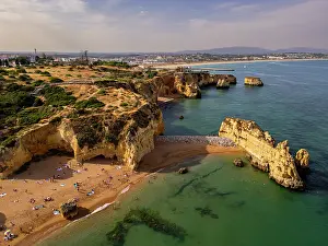 Gathering Prints: View of beach cliffs at sunset near Lagos in Algarve region of Portugal with people enjoying the sandy shore