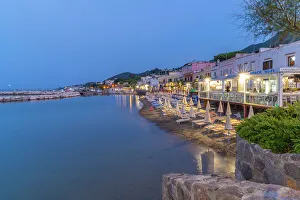 Chairs Prints: View of beach and the town of Lacco Ameno at dusk