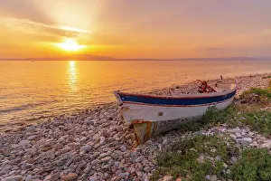 Pebble Beach Prints: View of boat on pebble beach near Skala Kallirachis at sunset