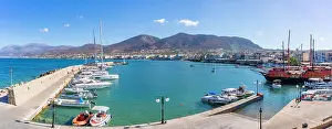 Fisherman Prints: View of boats docking in Port of Hersonissos with mountains in the background in Crete