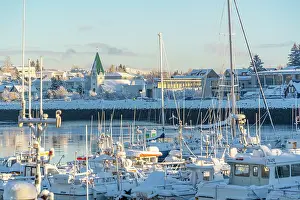 Voyages Prints: View of boats in Hafnarfjorour Marina and town in background in winter