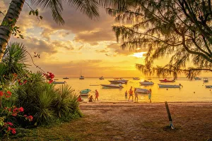 View of boats and people on Mon Choisy Public Beach at sunset, Mauritius, Indian Ocean, Africa