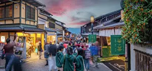 Pedestrians Prints: View of busy street and traditional wooden houses and shops in Gion