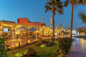 Hedge Prints: View of cafe and restaurant in Hurghada Marina and Al Mina Mosque in background at dusk
