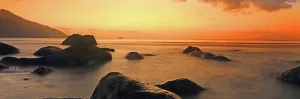 Tropics Prints: View of calm waters and rocks during sunset at a beach in Seychelles