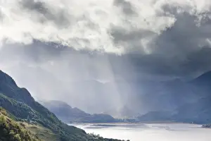 View from Carr Brae towards head of Loch Duich and Five Sisters of Kintail with rays of sunlight bursting through sky, Highlands, Scotland, United