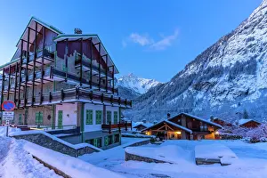 Cabin Prints: View of chalets and snow covered mountains in Courmayeur before dawn in winter