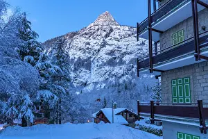 Chalets Prints: View of chalets and snow covered mountains in Courmayeur before dawn in winter
