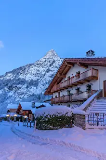Chalets Prints: View of chalets and snow covered mountains in Courmayeur before dawn in winter
