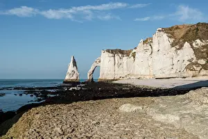 Stack Prints: View of the chalk cliffs and sea stack at Etretat in Normandy on a clear day with blue skies above