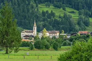 Wanderlust Prints: View of church surrounded by greenery in Kaprun during summer season in Austria's scenic landscape