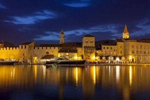 Trogir Prints: View of city across river, lit up at dusk