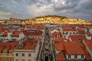 Streetscape Prints: View of city rooftops and Lisbon Castle from Santa Justa Lift during golden hour